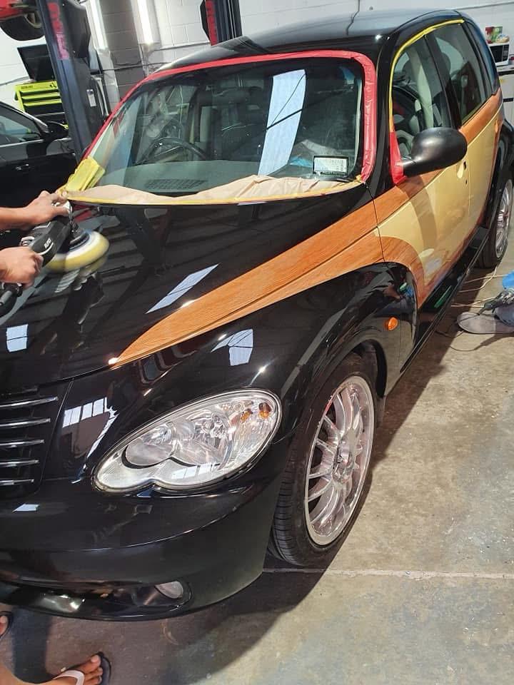 Machine polishing the black paintwork beside the finished woodgrain panels
