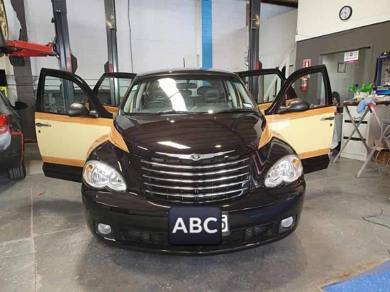 Front view of the finished car with its doors open in the workshop